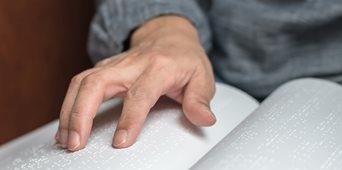 Stock image of hands on Braille