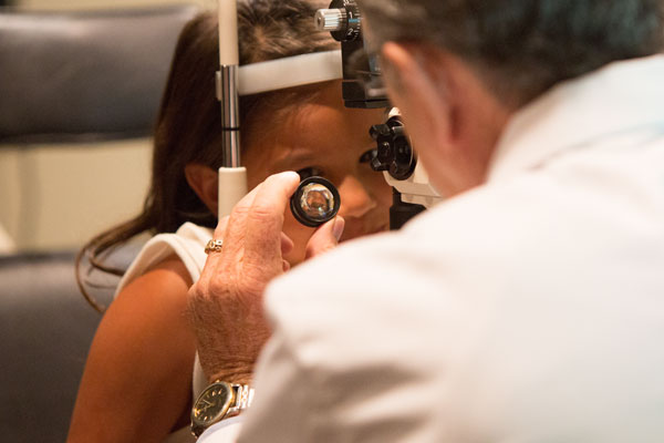 Young girl being given an eye examination by optometrist