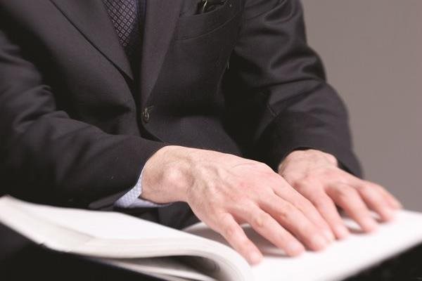 Stock image of hands on Braille