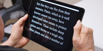 Woman reading iPad with text magnification