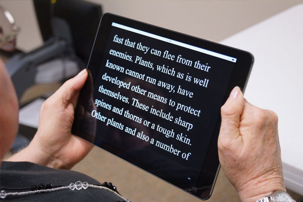 Woman reading iPad with text magnification